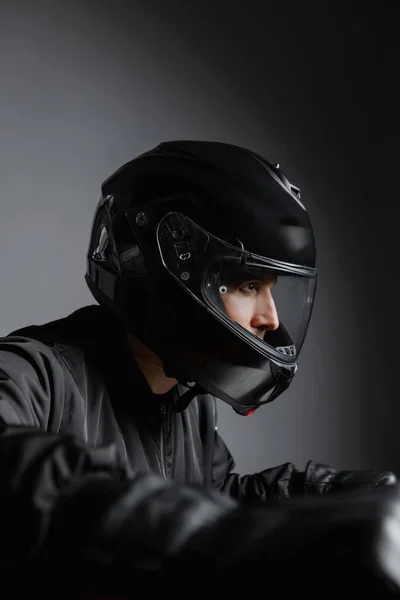 Motorkář na kole nosí helmu na koni motocykl uvnitř. — Stock fotografie