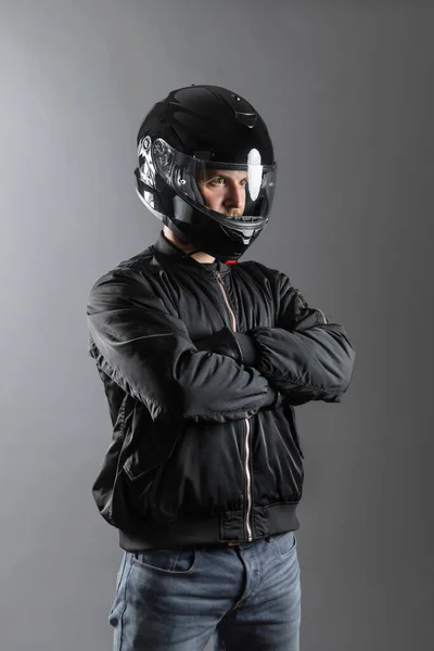 Studio shot of Motorcyclist biker in black equipment with crossed arms. — Fotografia de Stock