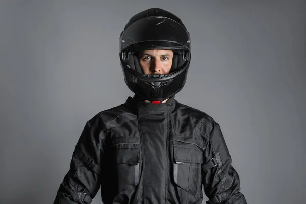 Studio shot of Motorcyclist biker in black equipment looking at camera. — Fotografia de Stock