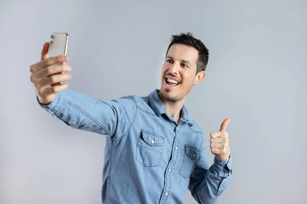 Hombre haciendo selfie disparo en el teléfono móvil, mostrando el pulgar hacia arriba. —  Fotos de Stock
