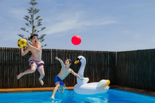 Dois Meninos Brincam Com Uma Bola Pulam Uma Piscina Água — Fotografia de Stock