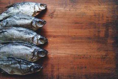 Kurutulmuş tuzlu balık. Eski ahşap bir masa yüzeyinde mavi çipura. Üst manzara, kopyalama alanı..