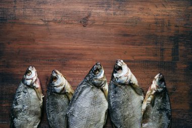Kurutulmuş tuzlu balık. Eski ahşap bir masa yüzeyinde mavi çipura. Üst manzara, kopyalama alanı..