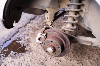 Merkez, fren diski, ped, benzincide tamir edilen bir arabanın arka tekerleğinin şok emicisi, yakın plan.