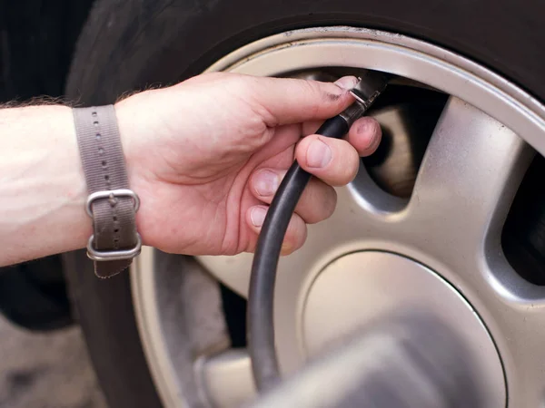 Händerna Man Och Automatisk Pump Eller Kompressor För Pumpning Bildäck Stockfoto