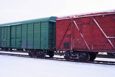 Kışın tren istasyonunda yük vagonları dolusu ahşap yük treni.