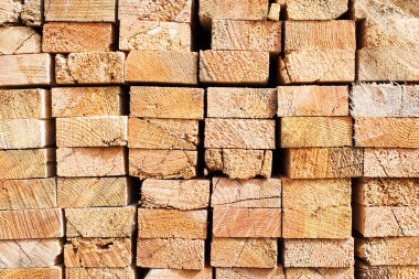 Tahta odunların arka planı, yakın plan. Tahtanın sonundaki yüzey. Yığılmış kereste, kereste, ahşap işçiliği