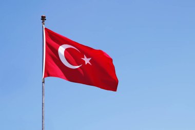 Turkey flag fluttering against blue sky background