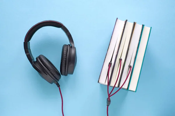 Schwarze Kopfhörer Mit Kabel Einem Stapel Bücher Auf Blauem Hintergrund — Stockfoto