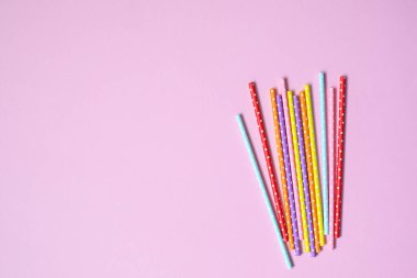 Pembe arka planda kokteyl içmek için renkli kağıt kamışlar. Metin ve tasarım için yeri olan düz bir yer. Ekoloji geri dönüşümlü ürün. Plastiksiz, ekoloji konsepti.
