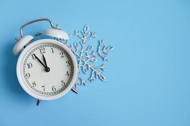 Yeni yıl beyaz alarm saati. Mavi, parlak bir Noel geçmişi. Gece yarısına beş dakika var. Yeni yılı kutlama kavramı.