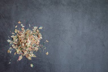 Keskin renkli kalemlerin talaşları. Tasarım ve metin için alan. Koyu arkaplan.