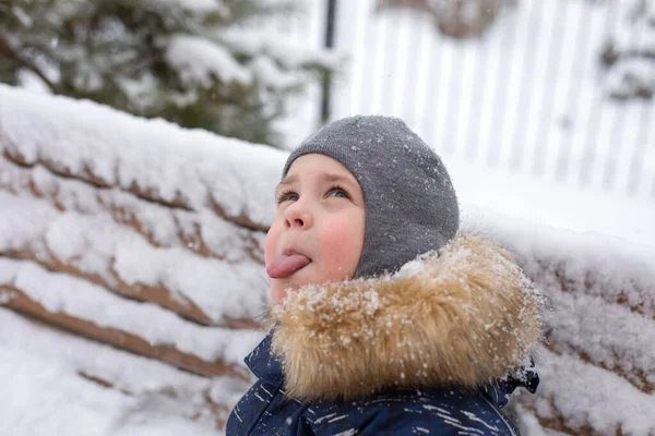 Little Boy Tries Catch Snowflakes His Tongue Winter Street Having — Stock Photo, Image