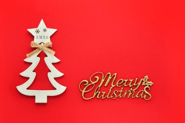 Mutlu noel kartları. Beyaz ahşap Noel ağacı ve parlak kırmızı bir arka planda Mutlu Noeller mesajı. Asgari Noel kavramı.