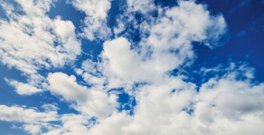 Pofuduk beyaz bulutlar parlak mavi gökyüzüne karşı. Doğa geçmişi. Pankart