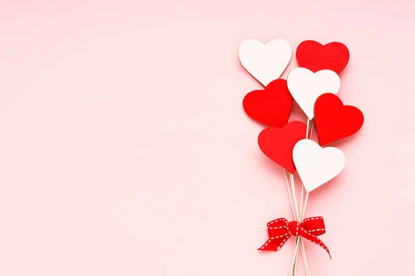 Dia dos Namorados fundo. Vermelho e branco corações de madeira no fundo rosa claro. Feriado festivo cartão de saudação — Fotografia de Stock
