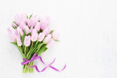Beyaz arka planda pembe kurdeleli pembe laleler. Anneler Günü, Sevgililer Günü, doğum günü konsepti