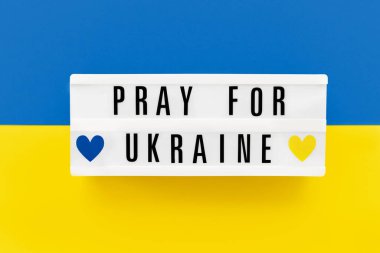 UKRAINE için Ukrayna bayrağının arka planında bir ışık kutusuna yazılmış dua