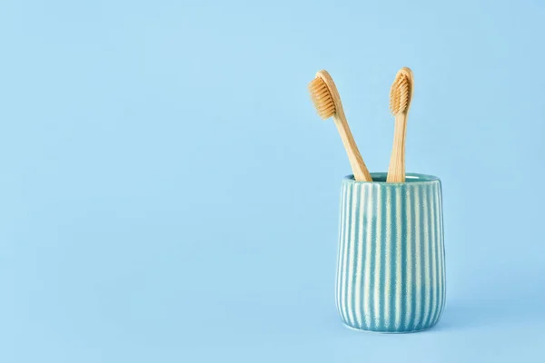 Dos Cepillos Dientes Bambú Soporte Cerámica Sobre Fondo Azul Concepto —  Fotos de Stock