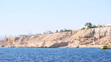 Kızıl Deniz 'in mavi dalgaları tarafından sürüklenen yüksek kayalıkların resimli görüntüsü. Dik kıyıların manzarası