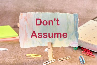 Kırtasiyenin yanındaki masanın üzerindeki mandalda bir kağıt parçasına yazı yazma..