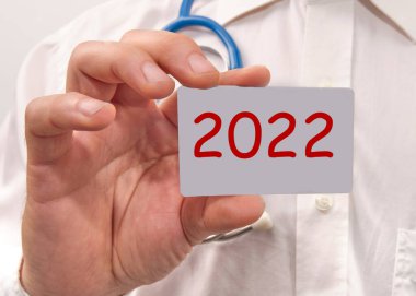 Doktorun elinde üzerinde 2022 yazan bir kart tutuyordu..