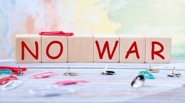 Savaş yok. Masadaki tahta küplerin üstünde ataç, düğme ve ataçlar var. Savaş Konsepti.