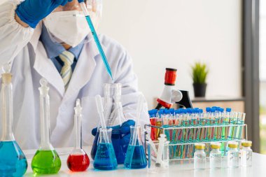 Bilim laboratuarı deney tüpü. Yaşam bilimi laboratuvarlarında çalışan genç sağlık araştırmacıları için bir cihaz. Genç bir bilim adamı mikroskopla hazırlar ve analiz eder.