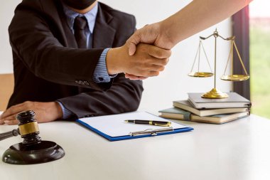 Masada çekiçler, teraziler ve kalemlerle birlikte sözleşmeli danışmanlık hizmetleri defterleri var. Erkek avukatlar arasındaki iyi iş birliği görüşmelerinden sonra erkek avukatın iş adamlarıyla el sıkışması planlandı..