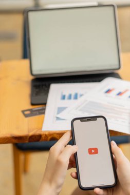08-10-2021 Chiang Mai, Tayland 'da YouTube izlemek için genç bir kadının elini telefonuyla tutuyor..