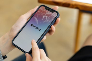 08-10-2021 Telefonunu tutan genç bir kadın Apple Müzik dinlemek için Chiang Mai Tayland