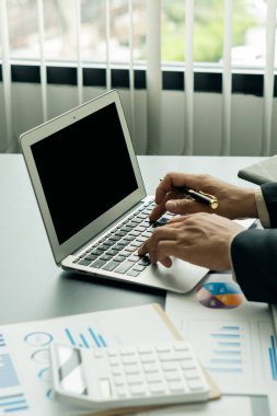 Hesap makinesini kullanan bir muhasebecinin portresi, elinde kalem tutarak para kazanmak ve masadaki ofis harcamalarını hesaplamak. Finans ve muhasebe bürosunda.