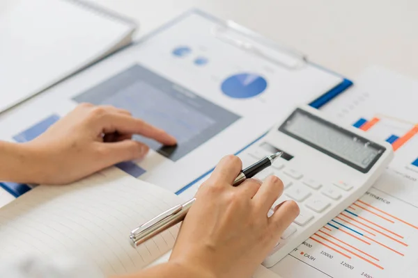 ビジネスマンはペンを保持し 彼の机のラップトップで毎月の会社の財務報告やオフィスの利益を計算し 分析するために計算機を押す 財務会計の概念 — ストック写真