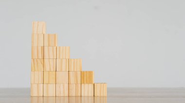 Adımlarla ahşap blokları üst üste yığmak iş büyümesindeki başarı kavramı beyaz bir arka plan masasında istiflenmiş tahta bloklar.
