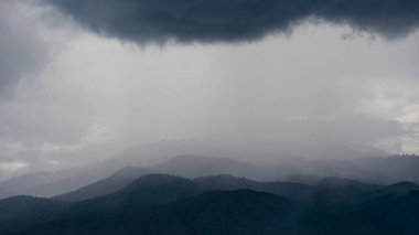 Manzara dağlara, mevsimlik yağmurlara ve güzel mavi bulutlara bakıyor..