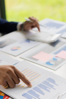 Elinde kağıt, finansal grafikler ve grafikleri gösteren kalem tutan bir işadamı var. ve iş ve dikey yakın çekim fotoğraf stokları için yatırım planlama