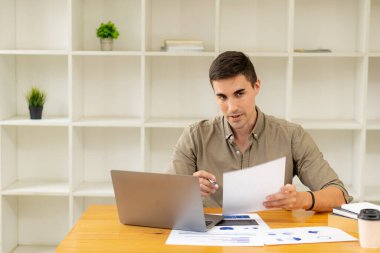 Ticari veri diyagramı olan dizüstü bilgisayarda çalışan iş adamı muhasebeciler mali raporları analiz ediyor. Grafikler, grafikler ve konsept hesap makineleri ile proje hesaplaması.