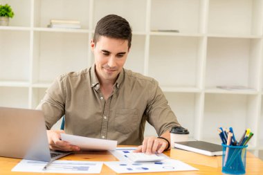 Ticari veri diyagramı olan dizüstü bilgisayarda çalışan iş adamı muhasebeciler mali raporları analiz ediyor. Grafikler, grafikler ve konsept hesap makineleri ile proje hesaplaması.