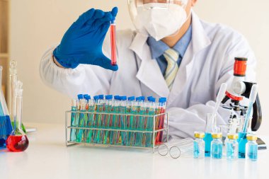 Coronavirus 'a karşı aşı geliştirmeye çalışan bir biyokimyasal araştırmacı ilaç laboratuvarında cam kaplı bir şişe tutuyor. Bilim laboratuarlarında araştırma ve geliştirme kavramları