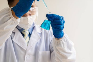 Coronavirus 'a karşı aşı geliştirmeye çalışan bir biyokimyasal araştırmacı ilaç laboratuvarında cam kaplı bir şişe tutuyor. Bilim laboratuarlarında araştırma ve geliştirme kavramları