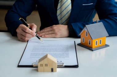 Bir emlakçı anlaşmayı imzalamak için örnek bir ev sigortası öneriyor. Satış sözleşmesinin belgeleriyle ya da kira sözleşmesiyle