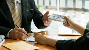İş adamının ahşap masadaki ortağından rüşvet alması para, rüşvet ve yolsuzlukla mücadele kavramını kullanarak anlaşmayı bozuyor..