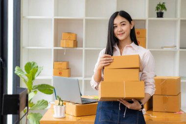 Küçük işletme girişimcisi, KOBİ ya da evde kutular ve dizüstü bilgisayarlarla, çevrimiçi satış fikirleri, e-ticaret, nakliyat, paketleme, çevrimiçi pazarlama ve nakliyat ile çalışan Asyalı serbest çalışan bir kadın kurmak.