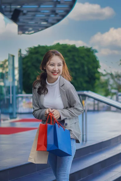 센터에서 쇼핑하는 아시아 쇼핑백 스마트폰을 — 스톡 사진