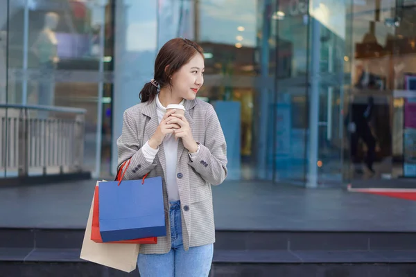 在购物中心背景下拿着购物袋和智能手机的女人亚洲女人在购物中心快乐购物 — 图库照片