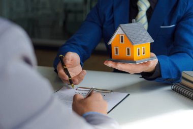 Ev satıcıları, evi satmayı kabul ettikten sonra yeni sahiplerine ev öneriyorlar. Bir emlakçı kiralamak ve satın almak müşterilere mülkiyet anlaşmalarını açıklamak