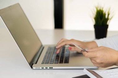 Online shopping concept paying via credit card with laptop computer and smartphone.