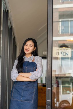 Restoran işletme fikrinin yanında bir tabelayla bir mağazanın önünde duran genç bir kadın..