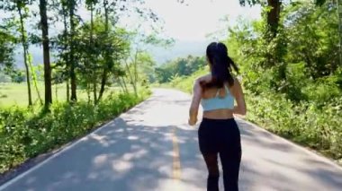 Akşam günbatımında parkta sağlık için koşan güzel Asyalı kadın. Sağlığı için açık hava.