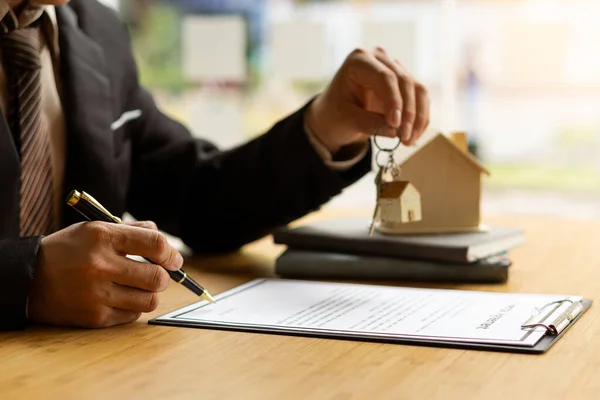 Der Immobilienmakler Hält Die Hausschlüssel Nach Vertragsunterzeichnung Büro Seine Klienten — Stockfoto